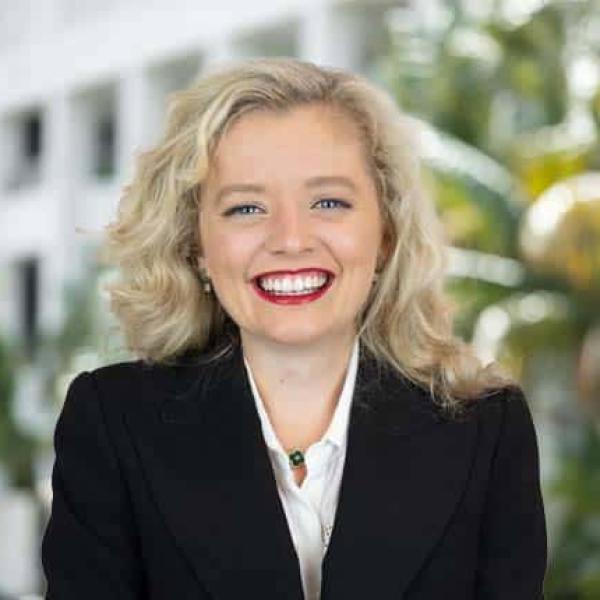 Helen McCormack is wearing a dark suit and smiling broadly at the camera