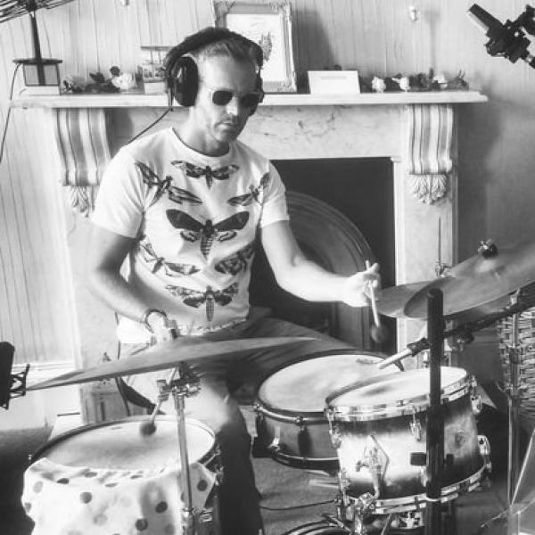 Dr. Stephen Davis wears shades and plays a drum kit