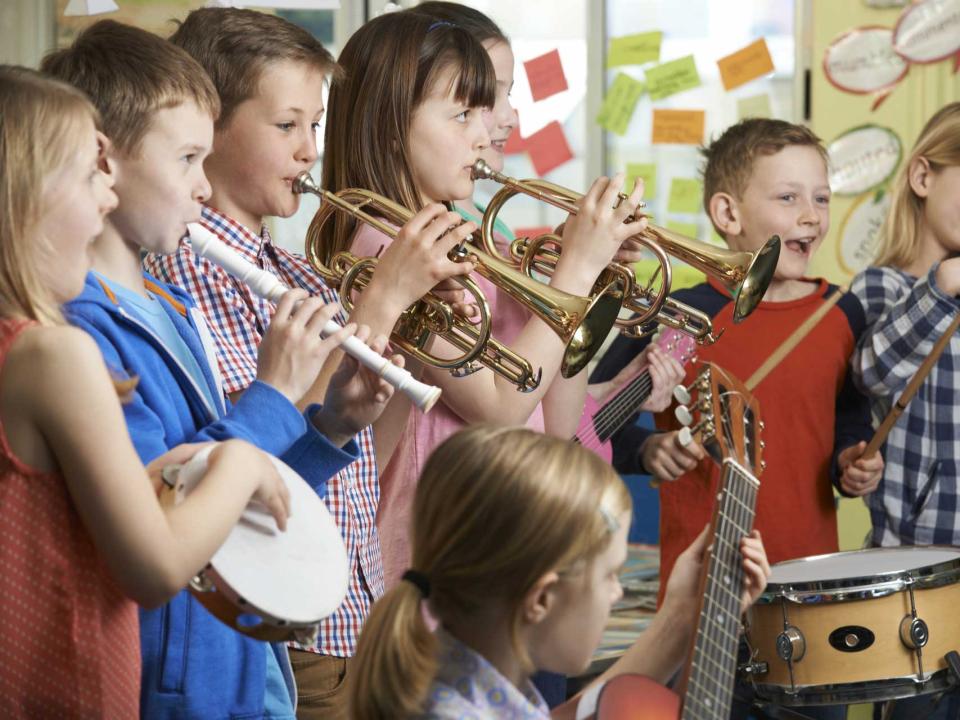 A group of children play musical instruments 