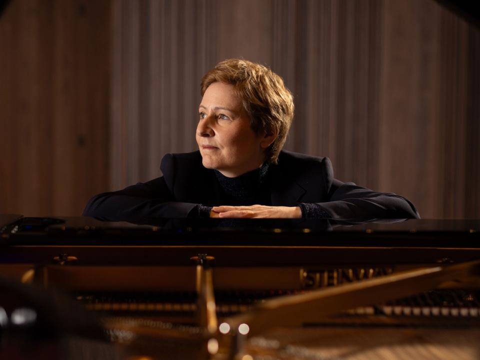 Deborah Kelleher, RIAM Director, leans on a piano