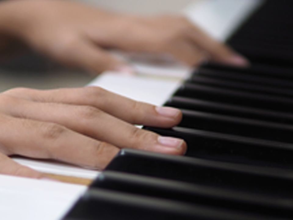 Hands on a keyboard of a piano