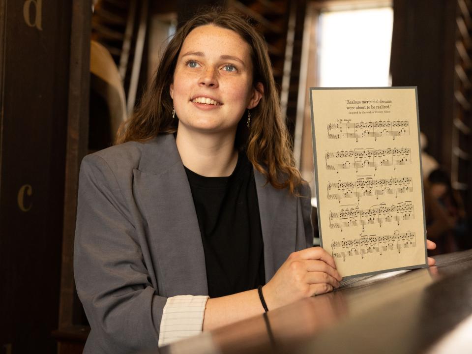 Aoife O'Donovan, Winner of Christy Nolan-Inspired Creativity Competition, poses with a beatiful printed music score of her compostion.
