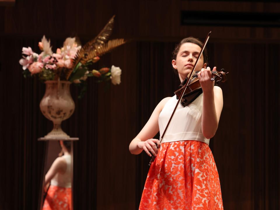 A person on stage playing a violin 