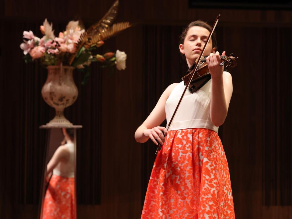 A person on stage playing a violin 