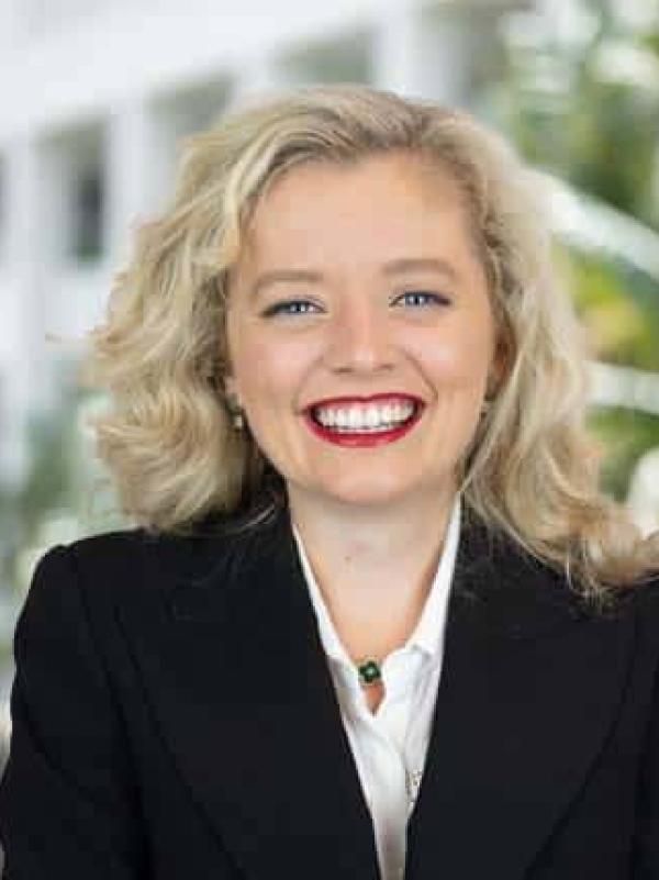 Helen McCormack is wearing a dark suit and smiling broadly at the camera