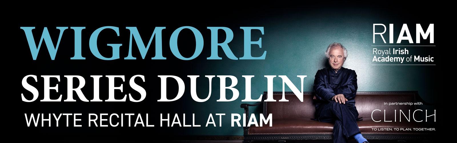 Pianist András Schiff sits on a red leather antique sofa with wooden arms and feet against a gradient turquoise to black background, crossing his legs and folding his arms in his lap. The image is overlaid with the title 'Wigmore Series Dublin. Whyte Recital Hall is at RIAM and features the RIAM logo and Clinch Wealth Management logo. 