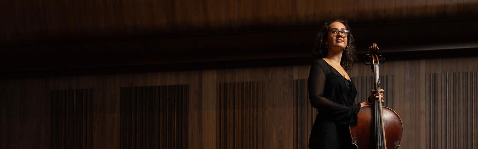 Anna Varga holds her cello on the whyte recital hall stage