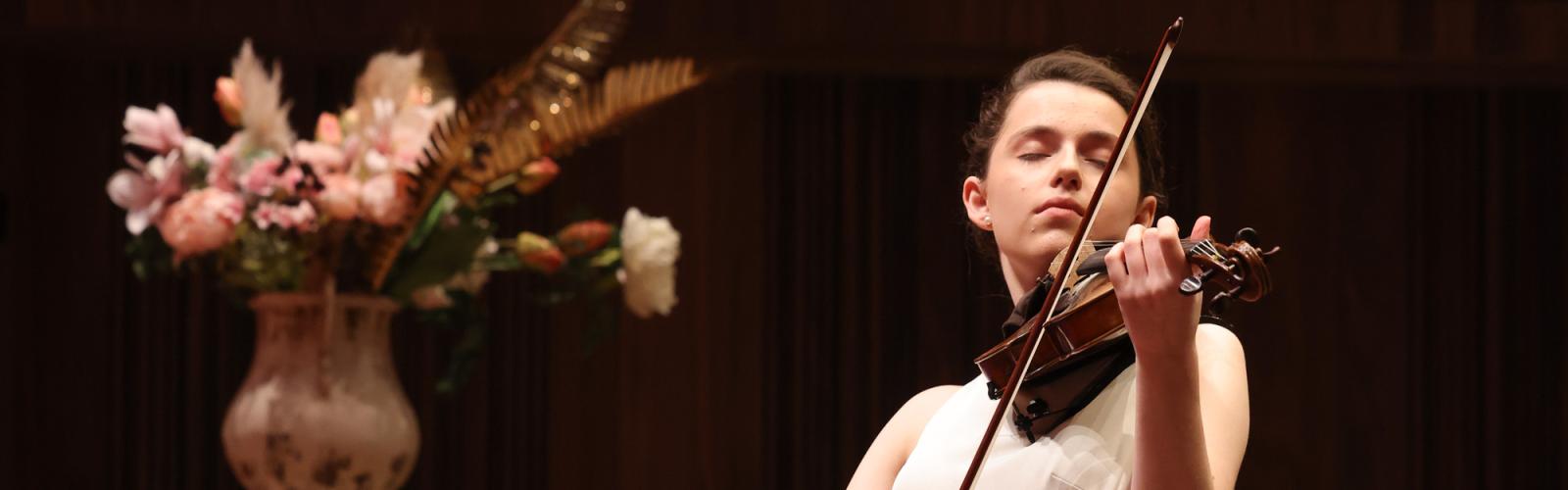 A person on stage playing a violin