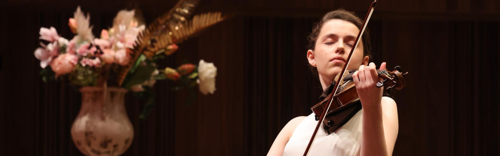 A person on stage playing a violin 