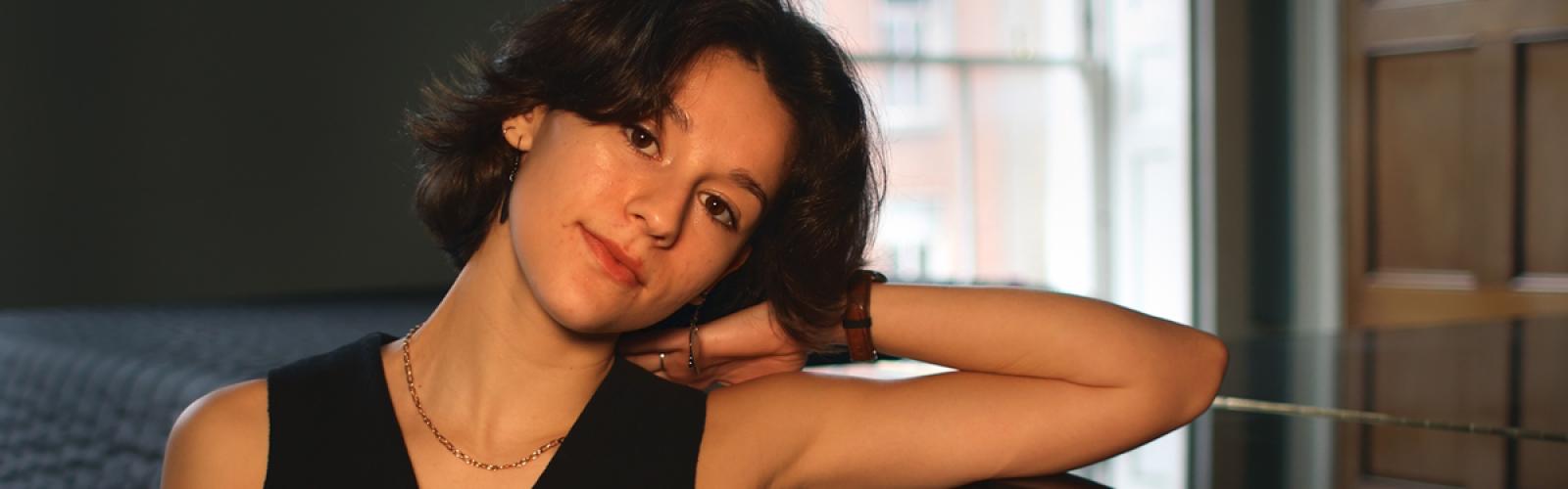 Sofia Féria leaning on a piano 