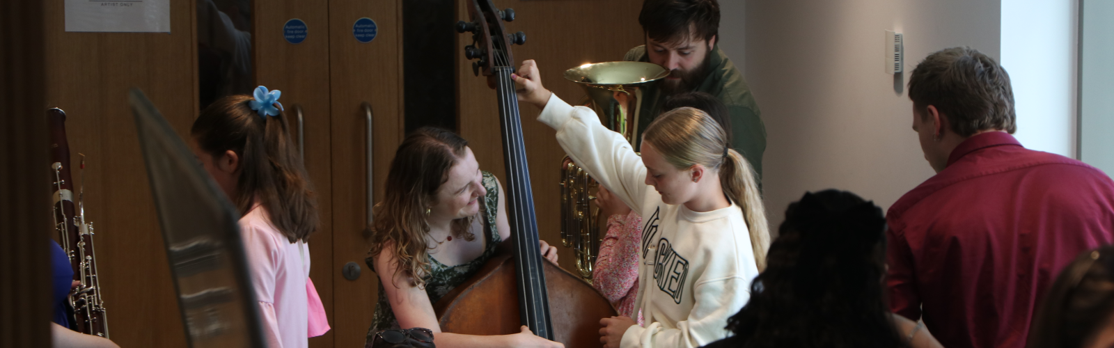 Image of tutors showing children the instruments of the orchestra